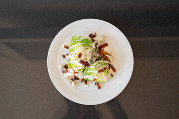 Wedge salad on white plate with black background view from above