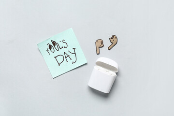Carton earphones and sticky note on white background. April Fools Day prank