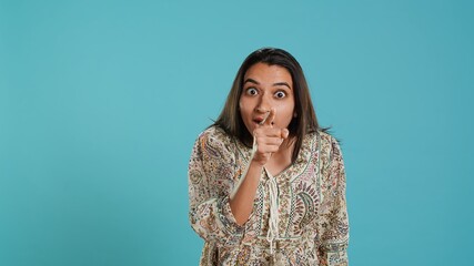 Irked indian woman fighting with boyfriend, doing scolding gesturing, isolated over studio...