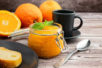 Delicious breakfast with homemade orange and mint jam. Glass jar with orange marmalade and mint...