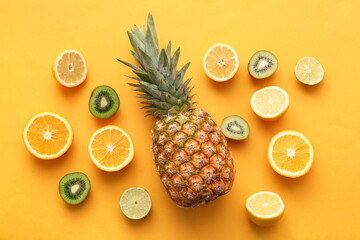 Fresh pineapple with different citrus fruits and kiwi on orange background