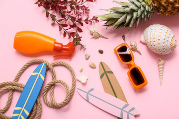 Sunglasses, surfboards, sunscreen cream and seashells on pink background. Summer concept