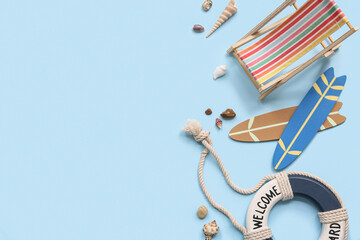 Deckchair, surfboards, lifebuoy ring and seashells on blue background. Summer concept