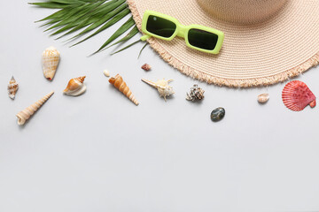 Beautiful seashells, hat and sunglasses on grey background. Summer concept