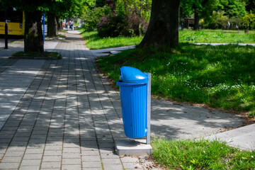 garbage bin in the park by the road