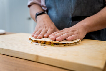 Chef at the kitchen preparing quesadillas with tofu and sweet corn