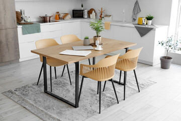 Interior of light kitchen with dining table and white counters