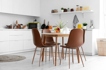 Interior of light kitchen with dining table and counters