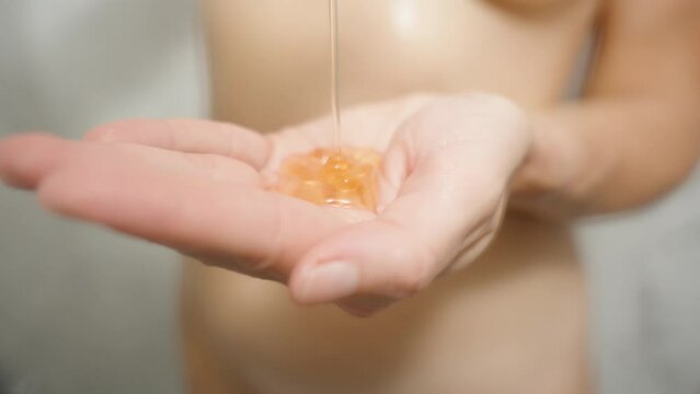 Naked Woman in the Shower pouring Orange Shower Gel into her hand. Slow motion.