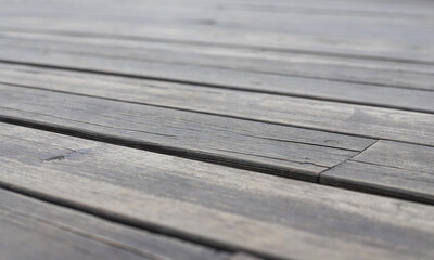 Fototapeta premium An old wooden gray pavement as a background. Photo in perspective with selective focus