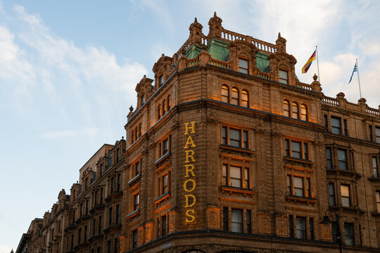 London, UK - March 22, 2024; Detail of Harrods department store sign illuminated on facade  in evening light