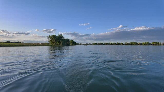Lake view behind a recreational rowing shell, rover POV perspective, springtime on Boyd Lake in Colorado