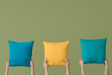 Women with bright pillows on green background