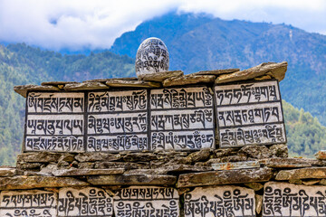 Nepal sacred stones mani with mantra written and carved on the surface. Prayer stones shire on the...