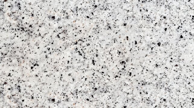 The fine polished finish of a white granite countertop giving it a sleek and sophisticated appearance with a subtle speckled texture