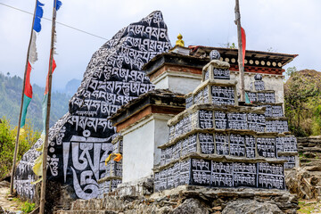 Nepal sacred stones mani with mantra written and carved on the surface. Prayer stones shire on the...