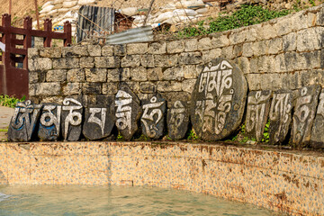 Nepal sacred stones mani with mantra written and carved on the surface. Prayer stones shire on the...