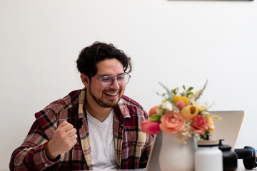 Gamer boy playing in his laptop in the living room with headset and getting emotions