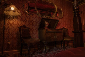This image shows the interior design of a red victorian, bordello themed room with an antique...