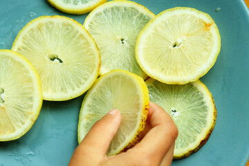 Pile of fresh lemon slices on blue plate