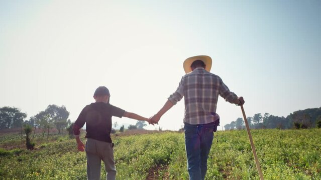 A young son listens to his father's advice while walking hand in hand.