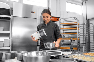 Experienced chef in professional kitchen preparing dough with flour to make bread