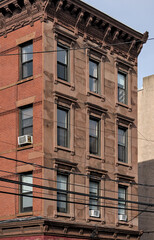 jersey city brownstone building detail (historic pre-war red brick buildings with power lines) beautiful real estate apartment homes with cornice decor urban city life window detail close up family