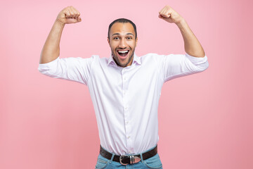 Excited man in white shirt showing his power with raised arms