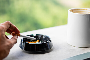 Coffee mug and ashtray on ledge with scenic background