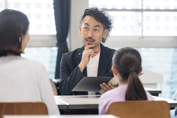面談を受ける親と子供　三者面談のイメージ　親子の顔無しのイメージ