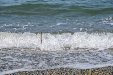打ち寄せる波に飲まれる棒