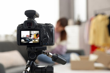 Fashion blogger showing her shoes while recording video at home, focus on camera