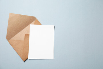 Letter envelope and card on grey background, top view. Space for text