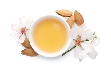 Almond oil in bowl, fresh nuts and beautiful flowers isolated on white, top view