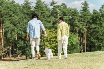 Fototapeta premium 愛犬を可愛がる飼い主の親子・犬の散歩（父親と娘） 