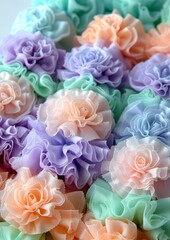 Fototapeta premium Delicate Pastel Fabric Flowers in Various Shades of Purple, Peach, and Mint Green Perfect for Decoration and Craft Projects
