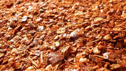 Zoom in reveals a lively blend of crimson chili flakes and seeds, boasting a coarse texture. Its fiery essence promises a robust, spicy kick, evident in the myriad of tiny flakes and seeds.
