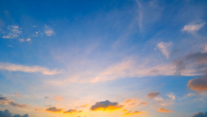 A beautiful sunset sky, transitioning from deep blue at the top to warm golden and orange hues near...