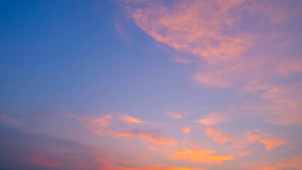 A beautiful sunset with soft, pink-tinged clouds spread across a gradient sky. The sky transitions...