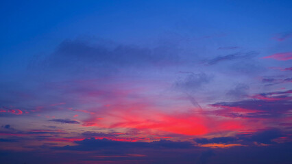 A stunning sunrise with a gradient of deep purples, vibrant pinks, and soft blues across the sky. Dark clouds create a dramatic contrast, accentuating the vivid colors of the morning light.
