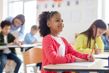 Back to school. African american schoolgirl pupil student attending school lesson and listening...