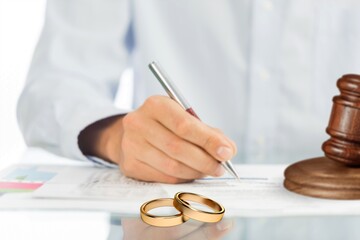 Wedding rings on table with judge gavel. Marriage and divorce