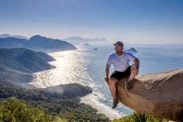 Adventurous climber hangs off Pedra do Telégrafo with breathtaking coastal view in Rio de Janeiro