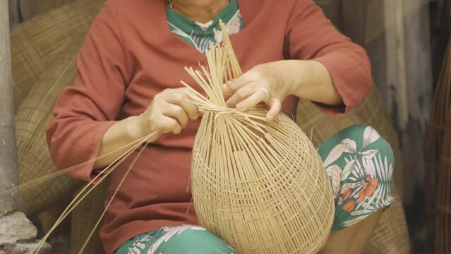 Worker weaving bamboo fish trap with basket in Hanoi, Vietnam. People lifestyle.