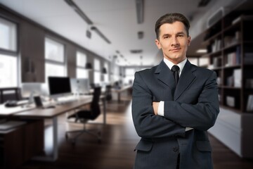 Happy young businessman leader standing in office.