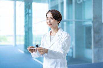 Obraz premium 名刺交換をする白衣を着た女性