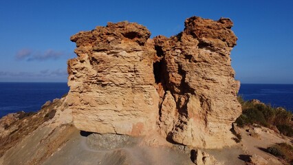 Flat rock formation Qarraba peninsula, close up on the cracked limestone where climbers can climb on the top. Ghajn Tuffieha , Qarraba peninsula, aerial close up. High quality photo