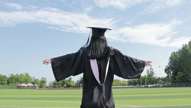 Young women college wear gown and cap, Fresh campus graduation season day student running through green landscape