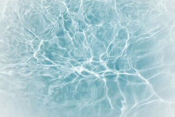 Blue water with ripples on the surface. Defocus blurred transparent blue colored clear calm water surface texture with splashes and bubbles. Water waves with shining pattern texture background.	
