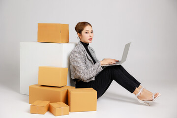 Portrait Asian smart entrepreneur business woman in casual suit surround by parcel boxes service...